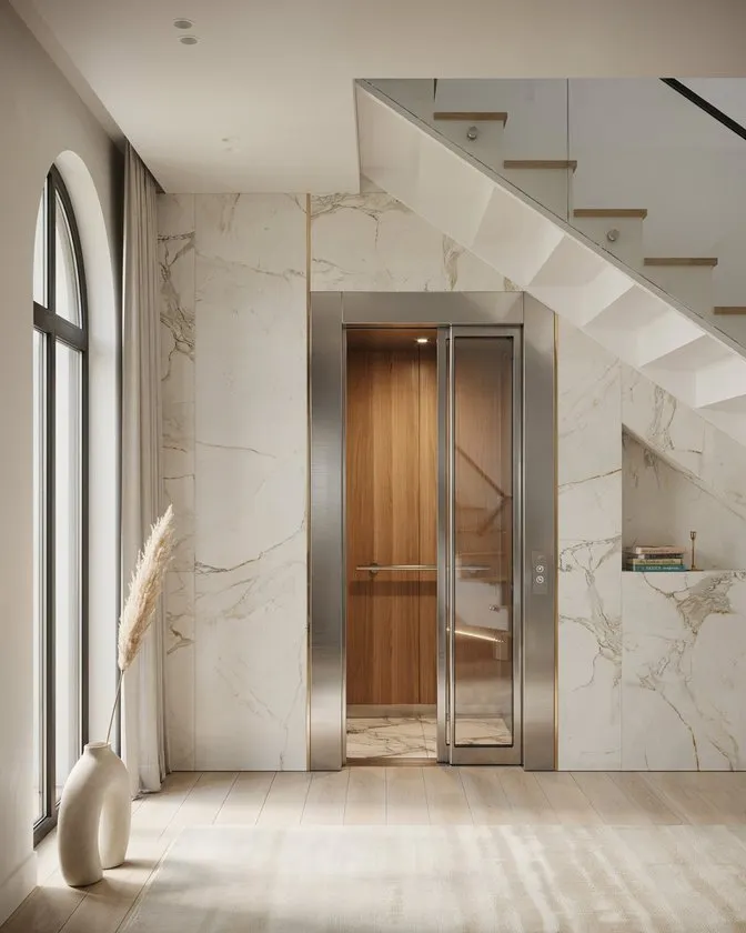 Compact residential elevator installed beneath a staircase in a modern Islamabad home.