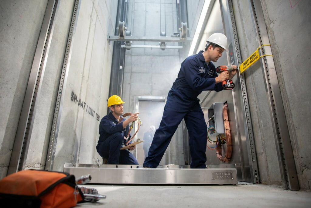 Certified elevator technicians installing and commissioning an elevator system inside the lift shaft for safe and reliable operation in Islamabad.
