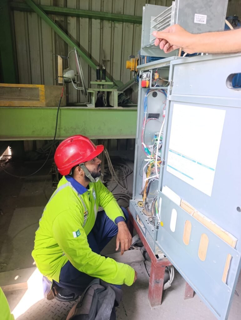 Technician inspecting and installing an elevator control panel during commissioning in Islamabad by Islamabad Elevator Solutions.